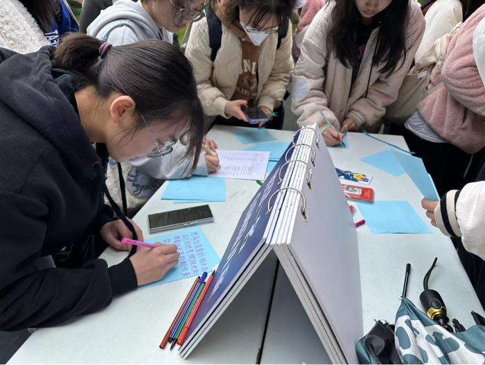 同学们在蓝色卡纸上写下自己对“星星的孩子”的美好祝福